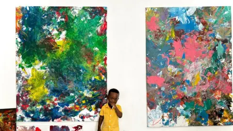 Chantelle Kuukua Eghan A toddler standing in front of abstract paintings