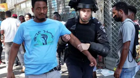 AFP An officer from Israel’s security forces detain an Eritrean asylum-seeker protesting an event organised by Eritrea's government in the coastal city of Tel Aviv, Israel - 2 September 2023