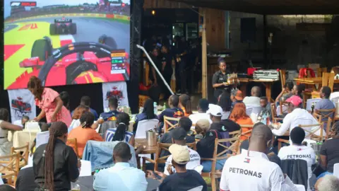 Paddock Experience Members of Paddock Experience, a Formula 1 club in Kenya, watching a race at an entertainment spot in Nairobi