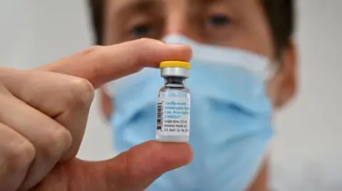 Getty Images Someone holding a vial of vaccine against mpox