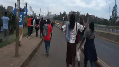 X/@mugambi_md People walking along a road with their hands up