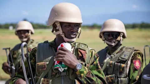 Reuters Members of a Kenyan police force, part of a new security mission, stand at the airport after disembarking, in Port-au-Prince, Haiti June 25, 2024