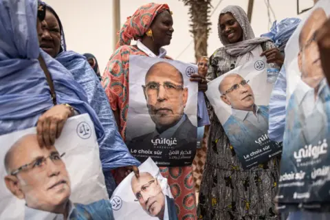  JOHN WESSELS/AFP  Supporters of the President of Mauritania and leader of the Union for the Republic, Mohamed Ould Cheikh El Ghazouani celebrate in Nouakchott on July 01, 2024. Mauritania's incumbent President Mohamed Ould Cheikh El Ghazouani has comfortably won re-election, receiving 56.12 percent of votes in the first round of the presidential poll, the Independent National Electoral Commission (CENI) said Monday. (Photo by JOHN WESSELS / AFP) (Photo by JOHN WESSELS/AFP via Getty Images)