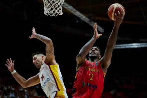 BORJA B HOJAS/GETTY IMAGES Angola's Silvio De Sousa and Spain's Willy Hernangomez vye for the ball during an Olympic basketball qualifier on Wednesday.