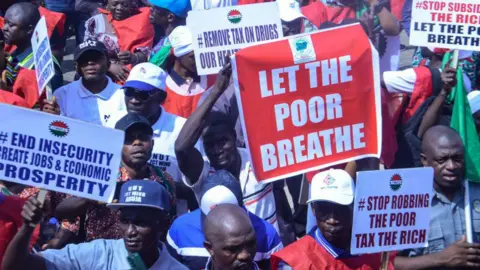 Getty Images Protesters with the Nigeria Labour Congress (NLC) gather at the National Assembly while holding placards during a protest against the recent raise in cost of living/economic hardship across the country in Abuja on February 27, 2024