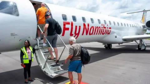 Getty Images Tourists board a FlyNamibia aircraft