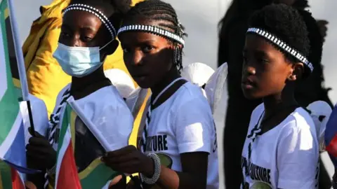 EPA Children dressed in Minwenda traditional attire from Venda wave South African flags before the start of Cyril Ramaphosa's inauguration ceremony as South African president at the Union Buildings in Pretoria, South Africa, 19 June 2024