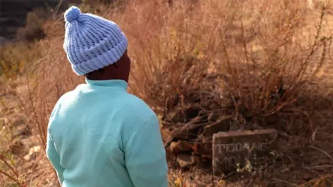 Ms Moloi at the grave of her son, Tlohang.