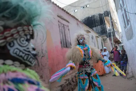 RICCI SHRYOCK / AFP  A performer dances in a traditional Simb costume during a cultural show at Ngor in Dakar, on 12 August 2024