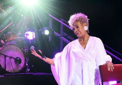 OUPA BOPAPE / GETTY IMAGES Abigail Kubeka stands on stage at a tribute show.