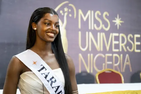  FAWAZ OYEDEJI / AFP Chidimma Adetshina smiles for the cameras. She has long, straight, black hair and is wearing a sash. 