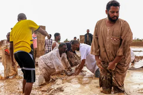 AFP Men create a make-shift levee out of mudbrick amidst flooding in the area of Messawi near Meroe.