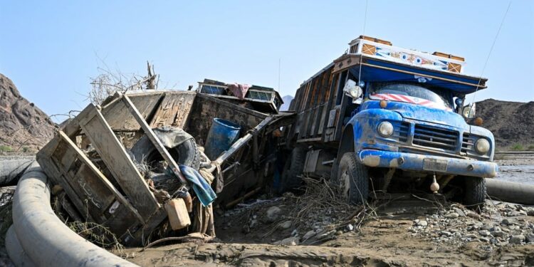 Damaged trucks buried in mud after the collapse of the Arbaat Dam, 40km north of Port Sudan, on 25 August 2024. (AFP)