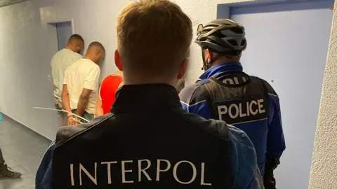 Interpol Officers pictured arresting people