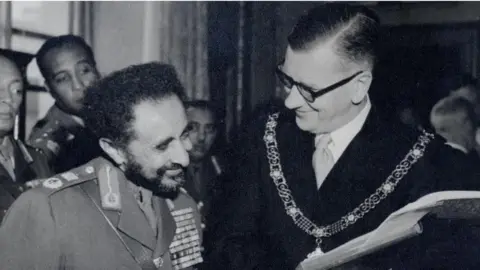 Bath and North East Somerset Council A black and white photo of Emperor Haile Selassie with the Mayor of Bath William Gallop. Both are in their unfirms and are smiling.