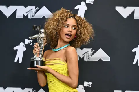 ANGELA WEISS / AFP South African singer-songwriter Tyla poses in the pressroom with the Best Afrobeats award for 