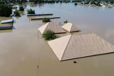 AUDU MARTE / AFP Roofs appear to float on water after devaastating floods.