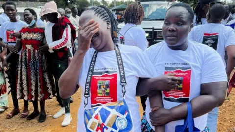 Reuters Agnes Cheptegei is assisted as she mourns her daughter and Olympian Rebecca Cheptegei, who died after her former boyfriend doused her in petrol and set her ablaze, at the Moi Teaching & Referral Hospital (MTRH) funeral home, in Eldoret, Kenya September 13, 2024