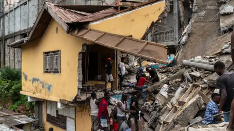  Prince Samura/EPA An image of a destroyed house as rescuers and residents dig for survivors in the rubble of a collapsed building collapse in Freetown, Sierra Leone - Monday 16 September 2024.