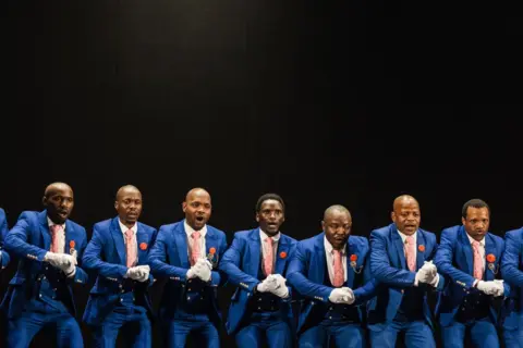 Rajesh Jantilal / AFP A traditional Isicathamiya group performs a traditional song and dance on stage at the Natal Playhouse Theatre in Durban, on September 21, 2024.