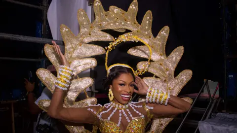 Emmanuel Adegboye / EPA An image of a Miss Universe contestant wearing a gold and white outfit backstage in Lagos, Nigeria - Saturday 31 August 2024