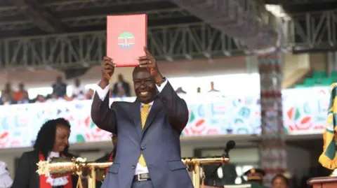 Getty Images Deputy president of Kenya Rigathi Gachagua holds a certificate during the swearing in ceremony at the Kasarani Stadium