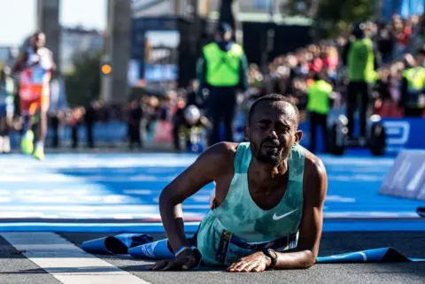 JOHN MACDOUGALL / AFP Ethiopia's Milkesa Mengesha lays on the ground - Sunday 29 September 2024