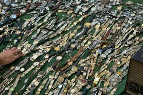 Khaled DESOUKI / AFP An Egyptian street vendor displays watches for sale at the Saturday market in downtown Cairo.