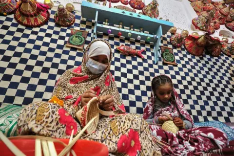 MAHMUD TURKIA/AFP Participants practice traditional basketry during the Ghadames Festival.