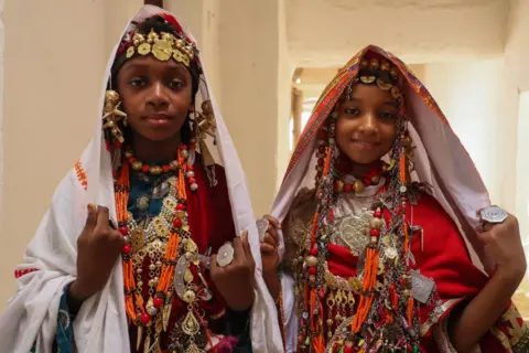 MAHMUD TURKIA/AFP Girls dressed in traditional attire pose for a picture during the Ghadames Festival celebrating the cultural and artistic heritage of the Libyan city.