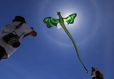 ESA ALEXANDER/REUTERS Journalists photograph kites during a practice run at Dolphin Beach ahead of this weekend's 30th Cape Town International Kite Festival, an awareness campaign for World Mental Health Day where kite enthusiasts gather to fly colourful kites to raise funds for mental health support, in Cape Town, South Africa, October 22.