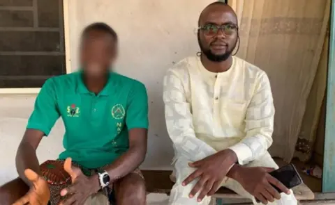 Advocacy For Alleged Witches Jude (left) sitting down wearing a green T-shirt with his face blurred and Dooyum Dominic Ingye (right) in a cream outfit