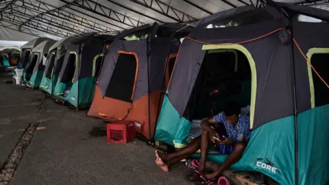 Getty Images Migrants at the Dr Alfredo Pumarej temporary shelter as they wait for appointments for temporary visas near the US-Mexico border in Matamoros, Tamaulipas, Mexico, on 14 September 2024