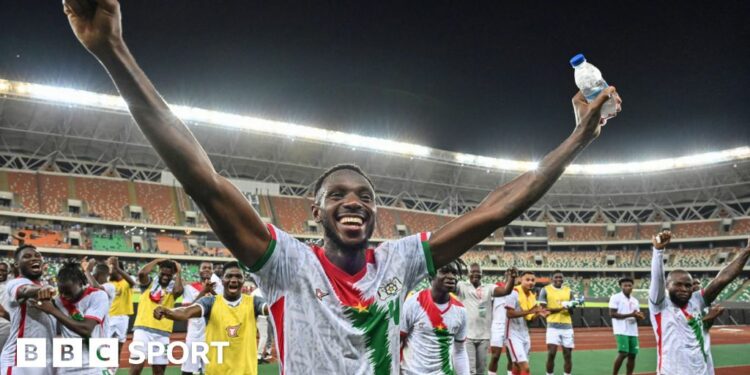 Adamo Nagalo celebrates with his arms outstretched above his head after Burkina Faso qualify for the 2025 Africa Cup of Nations