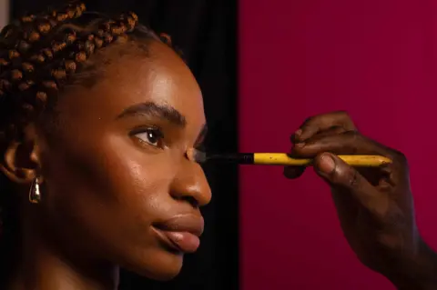 Emmanuel Adegboye / EPA A make-up artist applies powder to a model's face with a brush backstage during the Lagos Fashion Week on 25 October. Lagos Fashion Week runs from 24 to 27 October and showcases designs from Nigerian and African fashion designers.