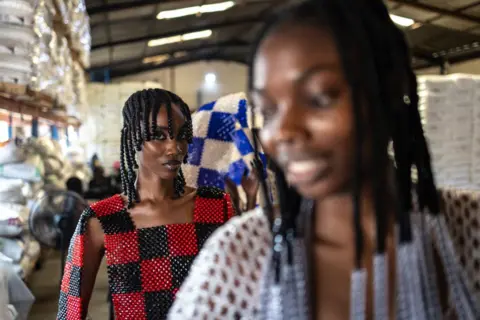 Olympia de Maismont / AFP Two models wearing checkerboard beaded clothing by Nigerian designer Bubu Ogisi at Iamisigo brand pose ahead of a private fashion show to launch the Spring- Summer 2025 collection during Lagos Fashion Week, on 27 October.