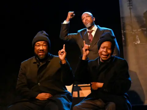 Oupa Bopape / Getty Images  Lebohang Motaung, Job Kubatsi & Sello Maake KaNcube at the opening of The Suit at Theatre On The Square in Sandton, South Africa. The timeless South African classic delves into themes of love, betrayal, and resilience in the face of apartheid-era hardships. 