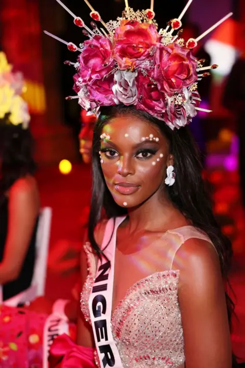 Yamak Perea / Getty Images Chidimma Adetshina attends the Miss Universe Catrinas Gala wearing a sequined pink dress and a Nigeria sash - Friday 1 November 2024