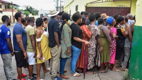 AFP People queuing outside a polling station to vote in Malabo - November 2022