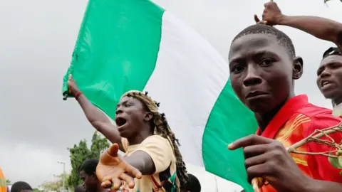 Getty Images Protesters with a Nigerian flag in Abuja, Nigeria - 2 August 2024