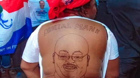 Mahamudu Bawumia A supporter of Mahamudu Bawumia reveals her bare back, which is covered in a sketch of the presidential candidate. The words 