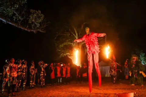 Cem Ozdel / Getty Images A man or woman walks on stilts.