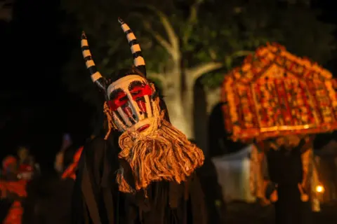 Cem Ozdel / Getty Images People in masks sway.