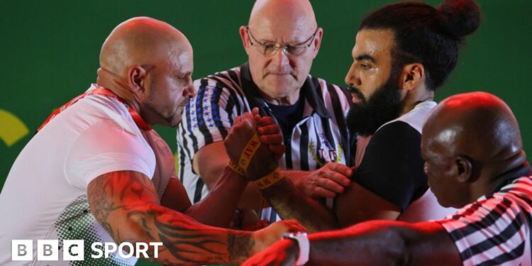 South Africa's James Kruger (left) competes against Egypt's Mustafa Mohamed (right) in the senior men's left arm wrestling competition during the 2023 African Games in Accra, Ghana.