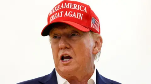 Getty Images Donald Trump wears a red hat emblazoned 