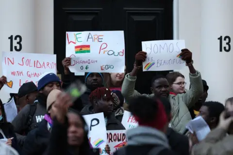 AFP Dozens of protestors stand outside the Ghanian embassy in London holding placards against the anti-LGBTQ+ bill