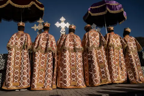 AMANUEL SILESHI / AFP Clergy wear embroidered robes and carry large, ornate crucifixes.