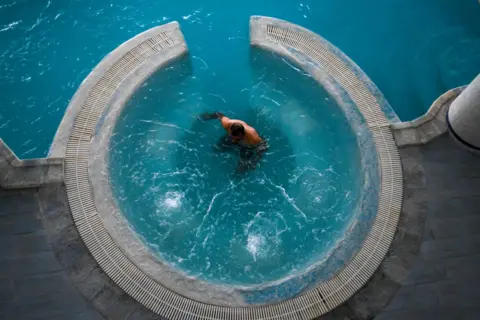 FETHI BELAID / AFP A man immerses himself in a round pool.