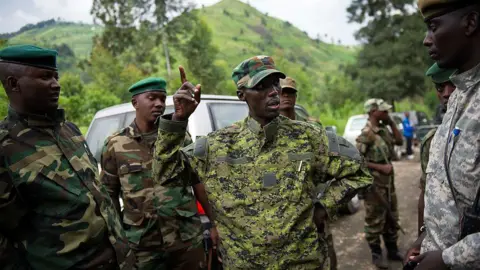 AFP Sultani Makenga, dressed in military fatigues, addresses a group of fighters